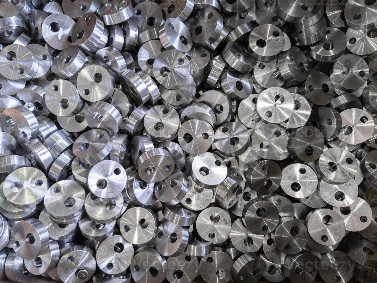 full frame view on heap of round steel cylindrical parts after eccentric drilling photo