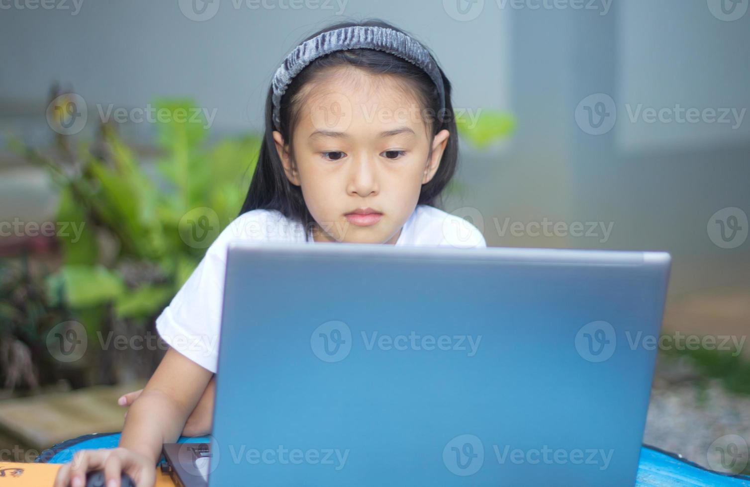linda niña asiática usando laptop foto