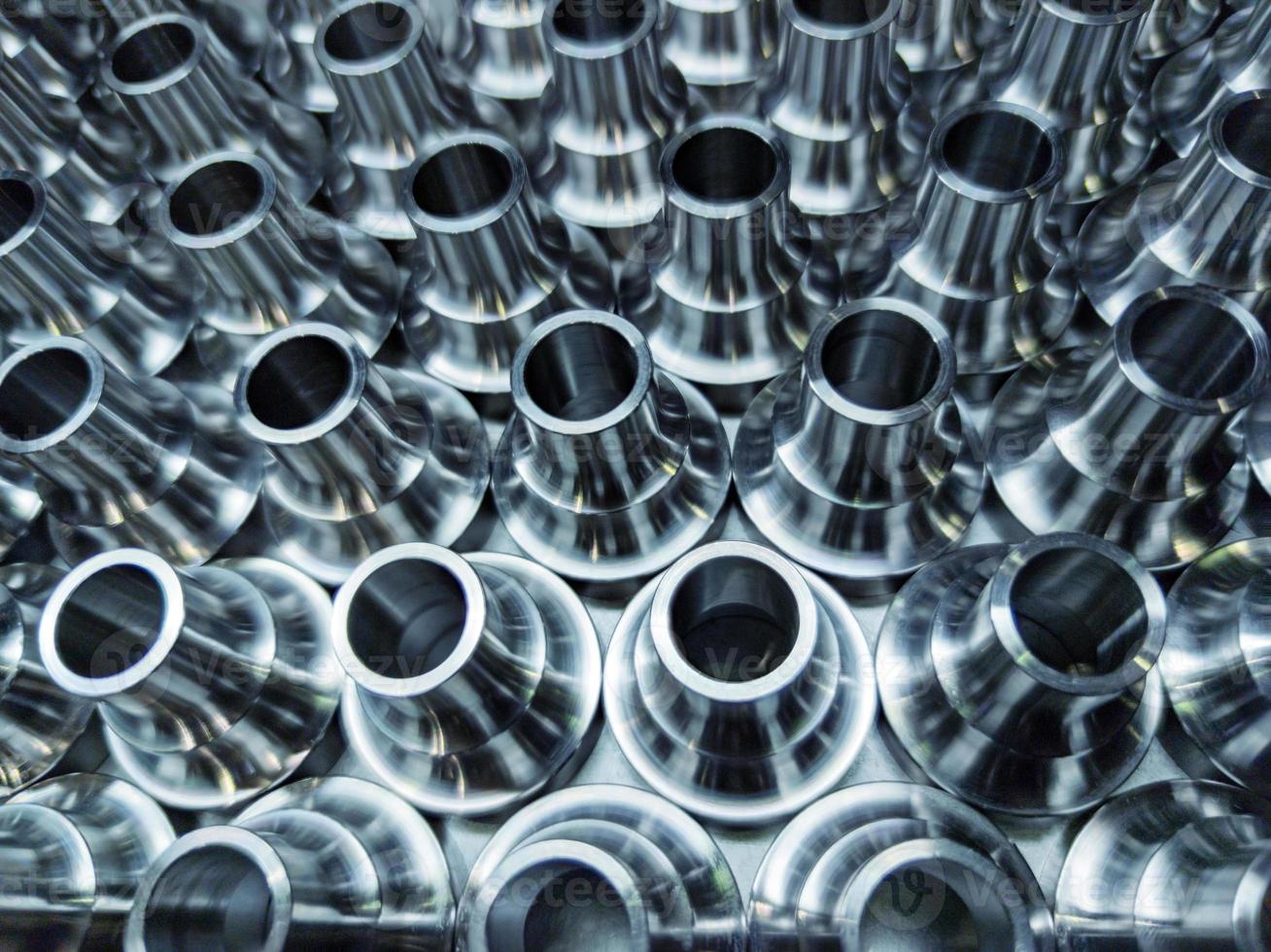 a batch of shiny steel cnc aerospace parts production - close-up with selective focus for industrial background photo