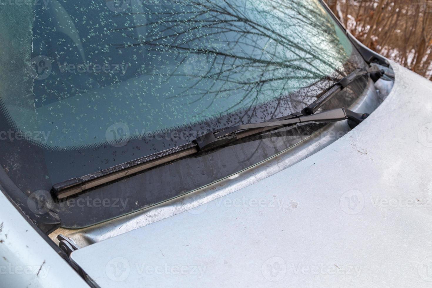 escamas de escarcha ligeras en el parabrisas del coche por la mañana y en los limpiaparabrisas de hoja de agua foto