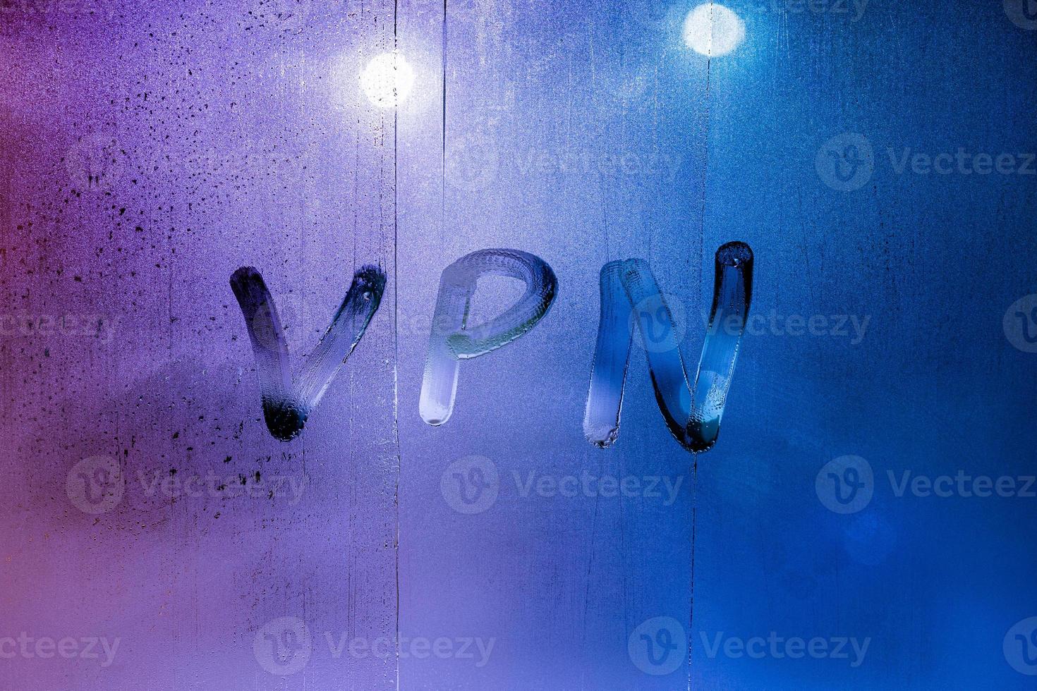 an abbreviation VPN - virtual private network drawed by finger on night wet glass photo