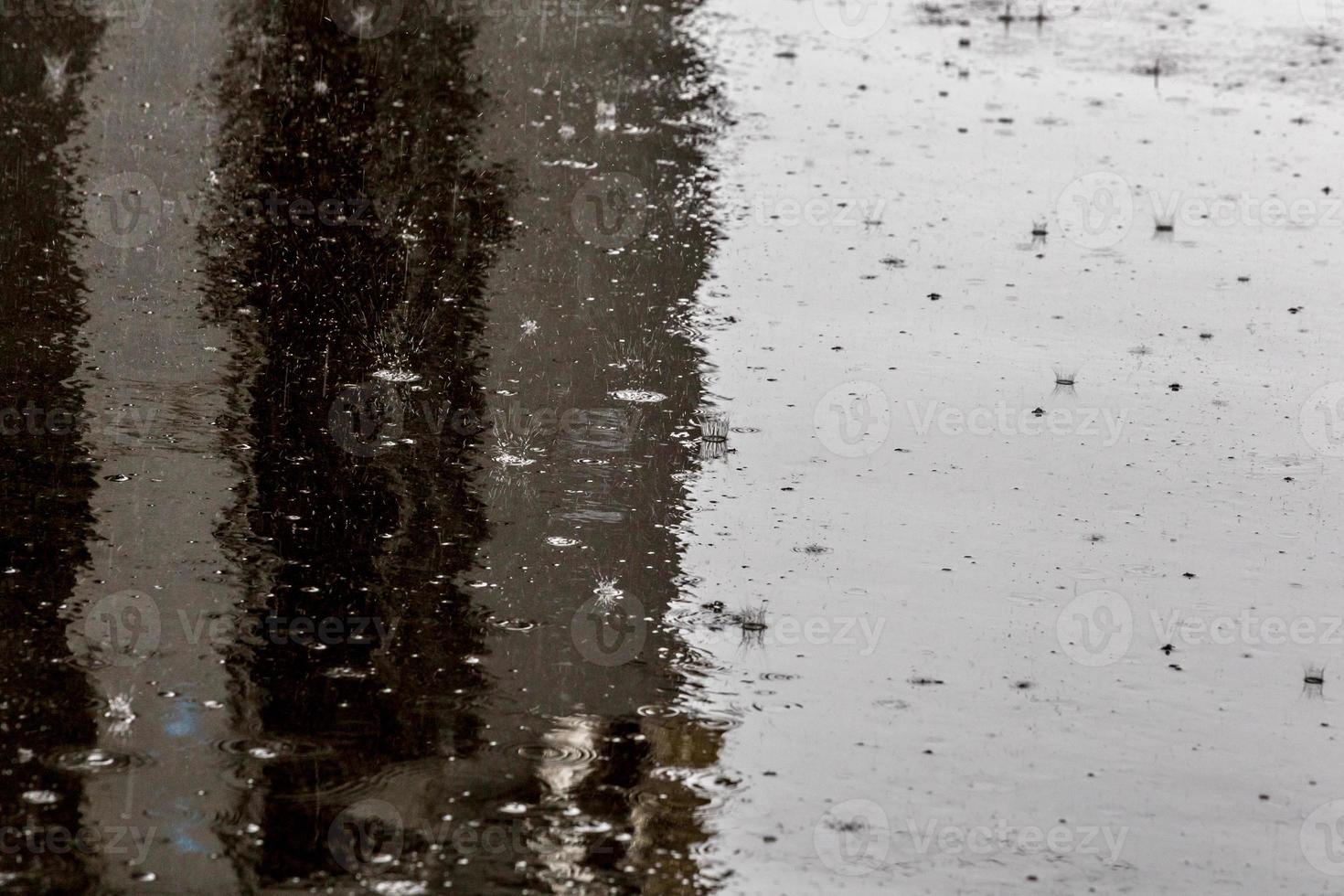 Raindrops on shiny wet flat asphalt background with selective focus. photo