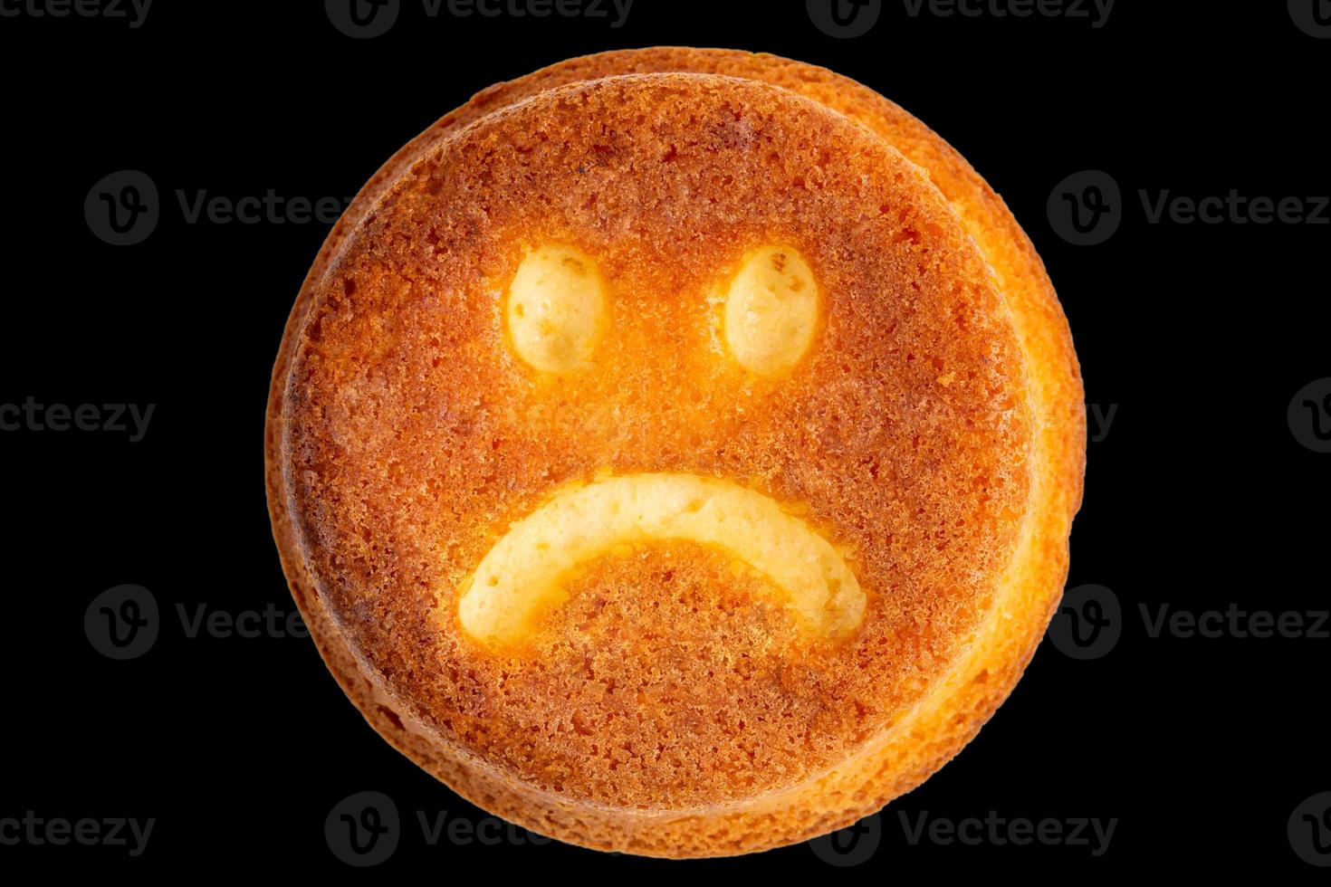 unhappy face biscuit cookie isolated on black in flat lay perspective photo