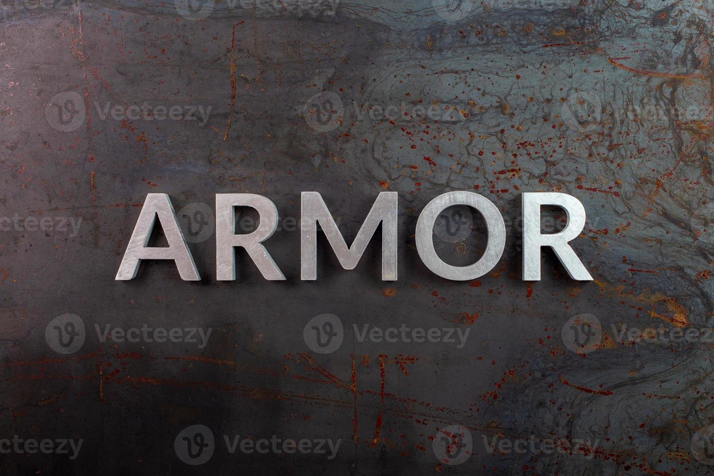 the word armor laid with silver metal letters on rusted iron flat surface background photo