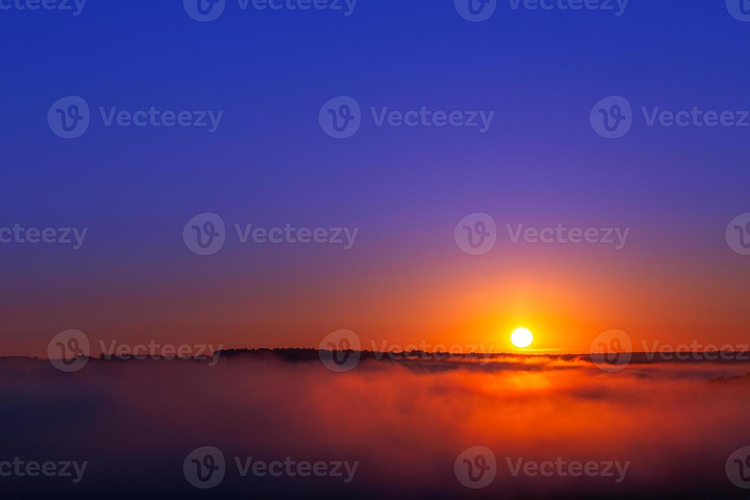 golden-blue summer sunrise over fog without clouds in minimalistic composition photo