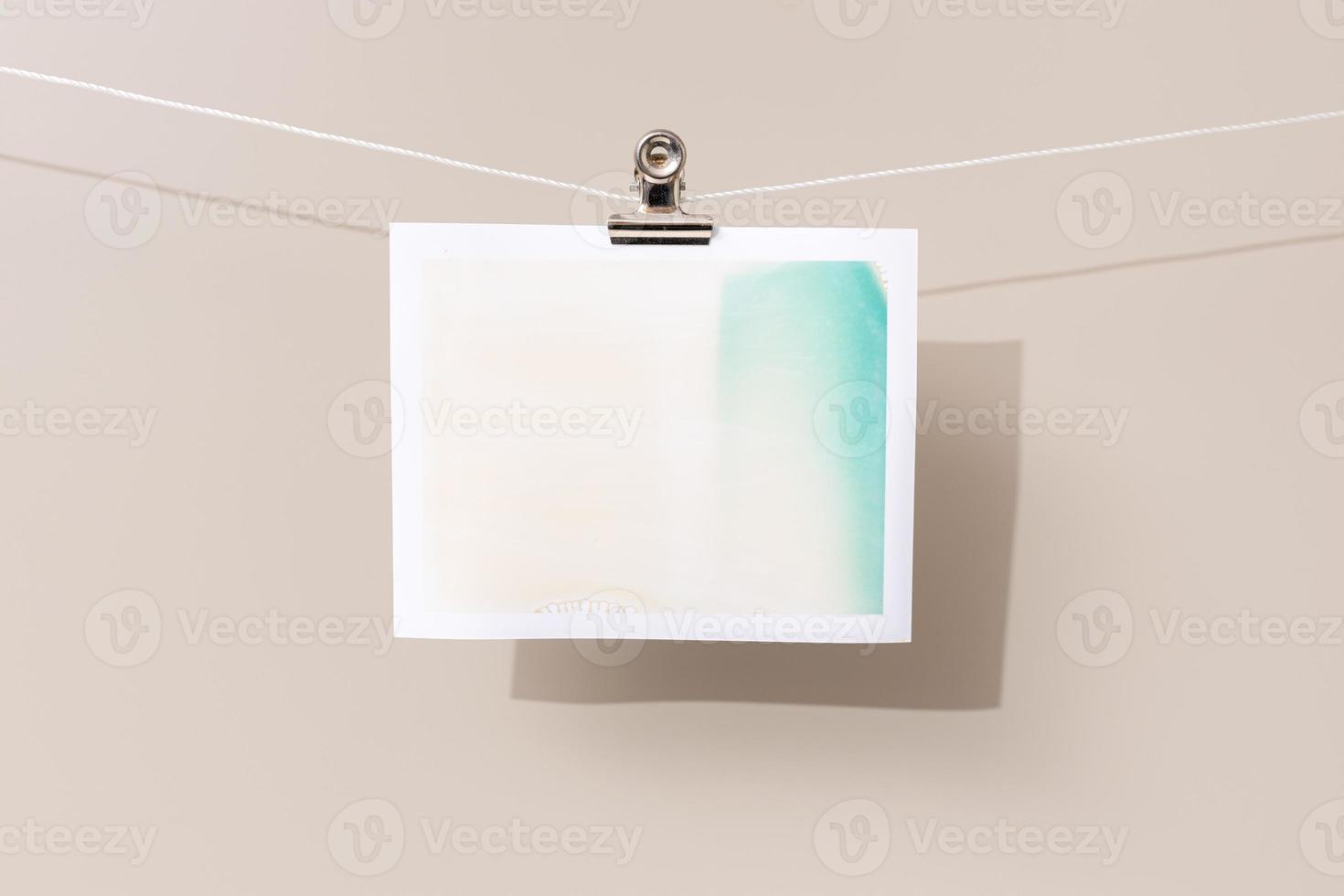 instant photo frame with green and beige patches hanging on a rope