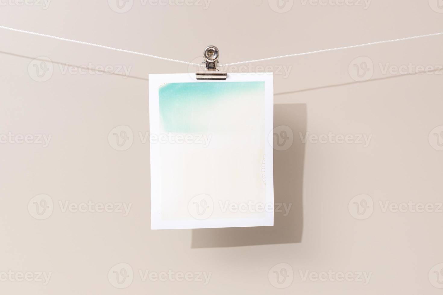 instant photo frame with green and beige patches hanging on a rope