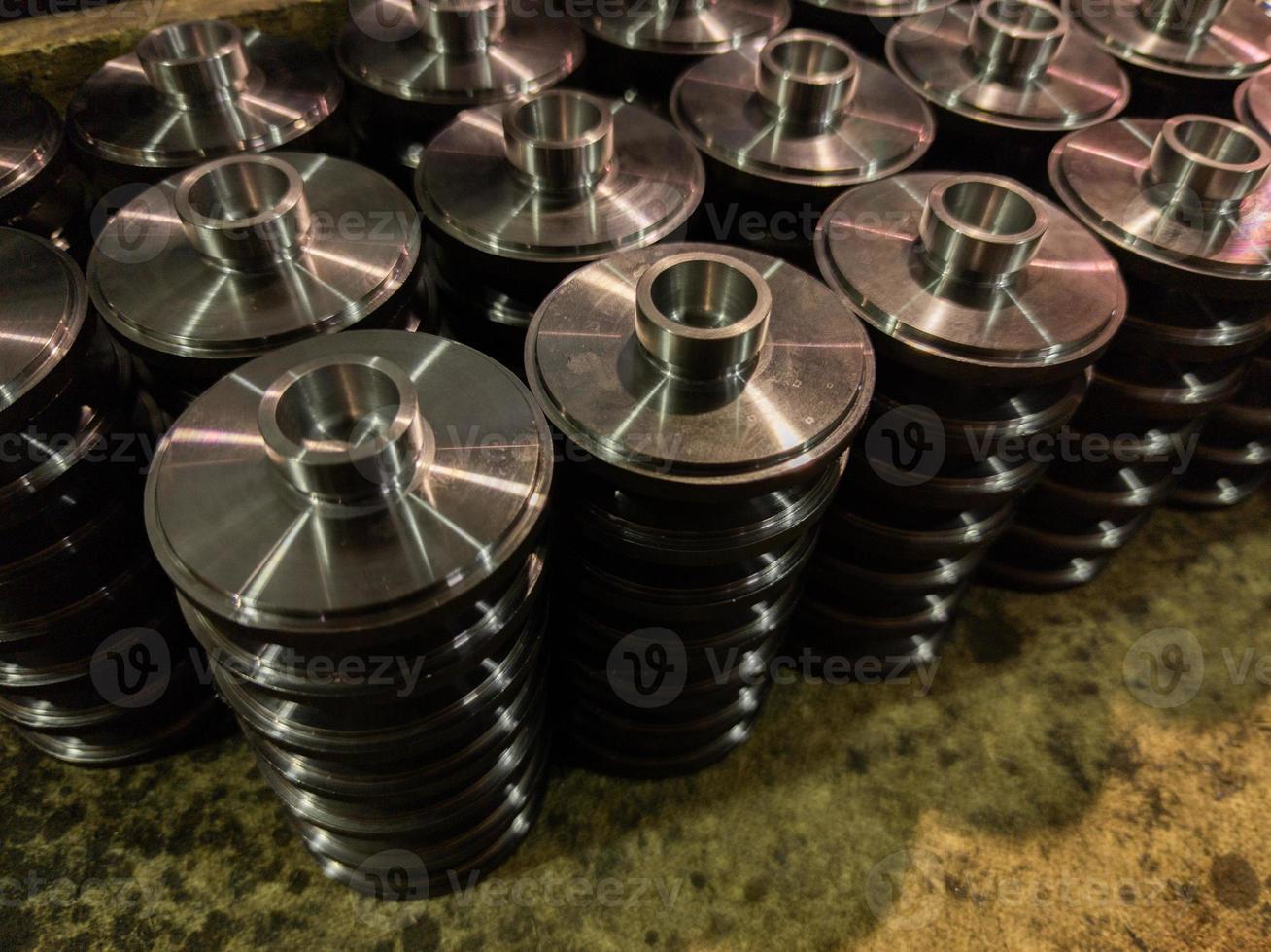 stacks of batch production round parts in a wooden box photo