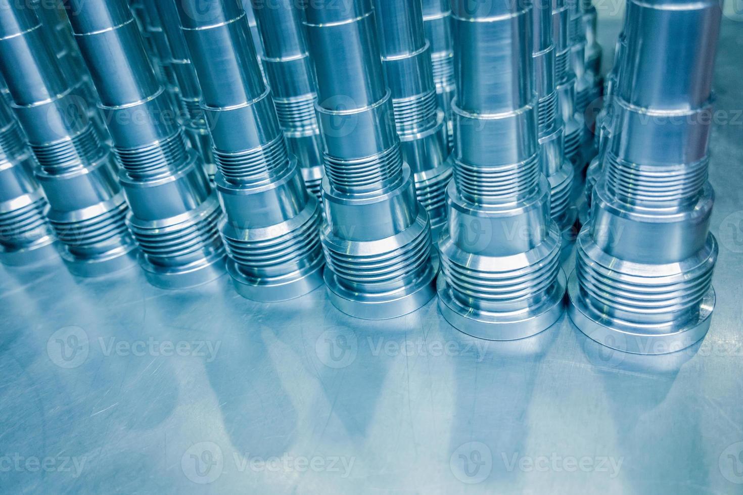 Shiny blue steel parts background, long clean steel rods after fine cnc turning. photo