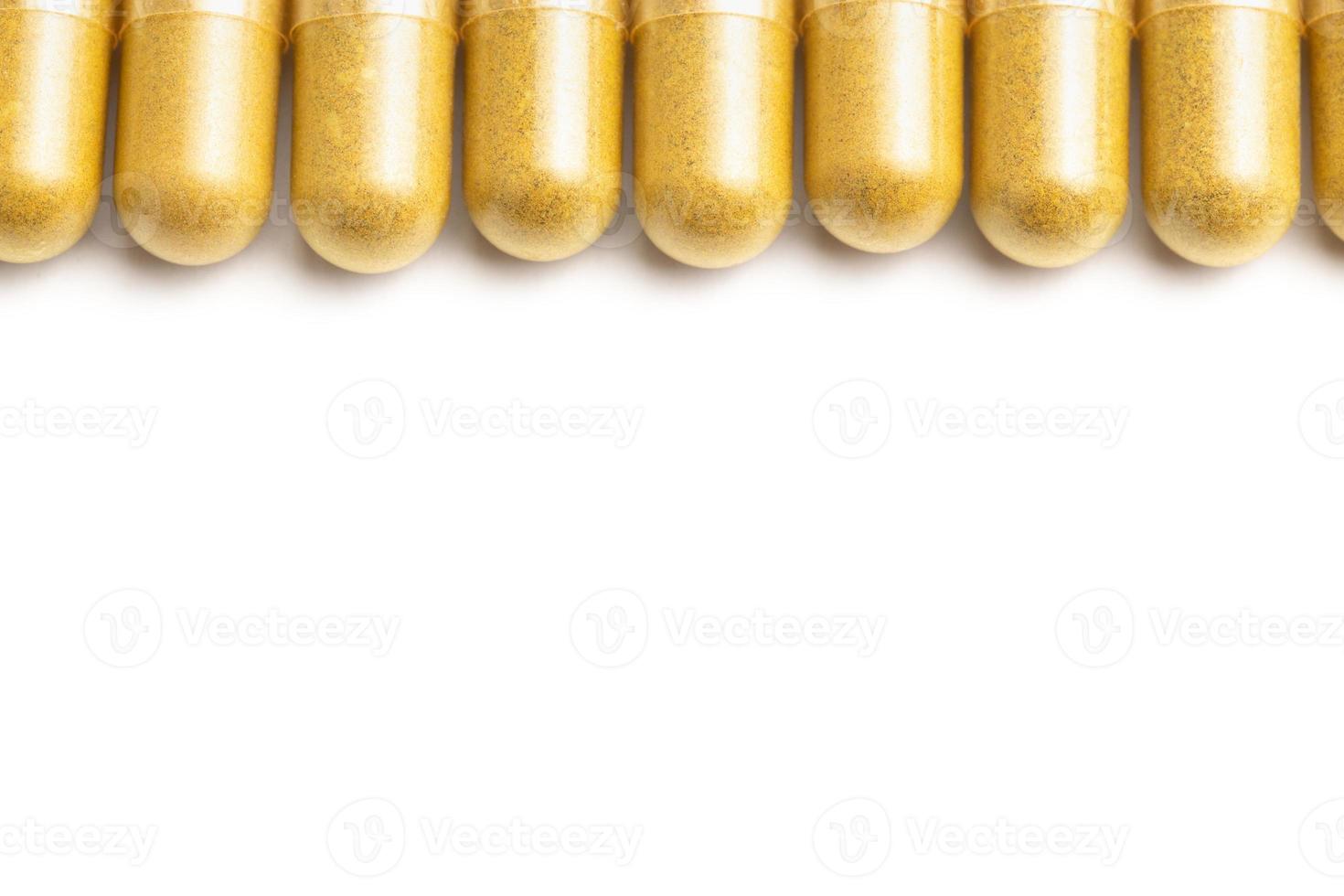 row of orange color organic capsules isolated on white background closeup with selective focus photo