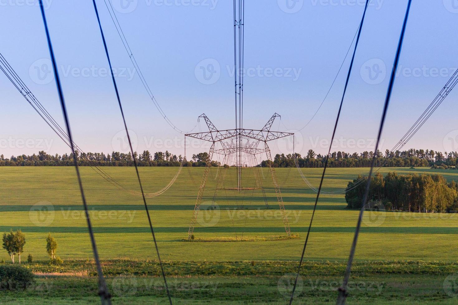 enormes torres de líneas eléctricas en el campo en las noches de verano foto