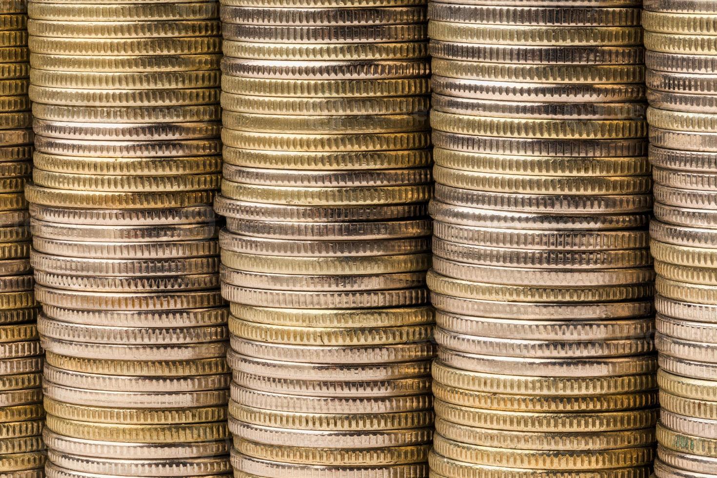 Five equal stacks of coins merged in one solid wall macro background photo