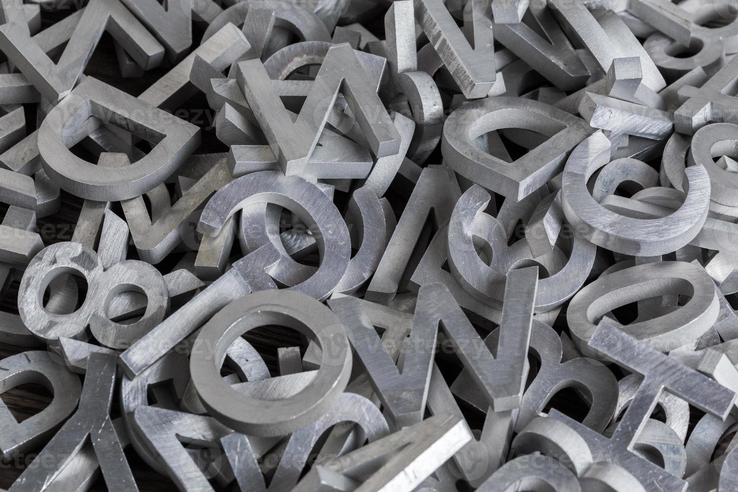 pile of white metal alphabet characters cutted by waterjet machine photo