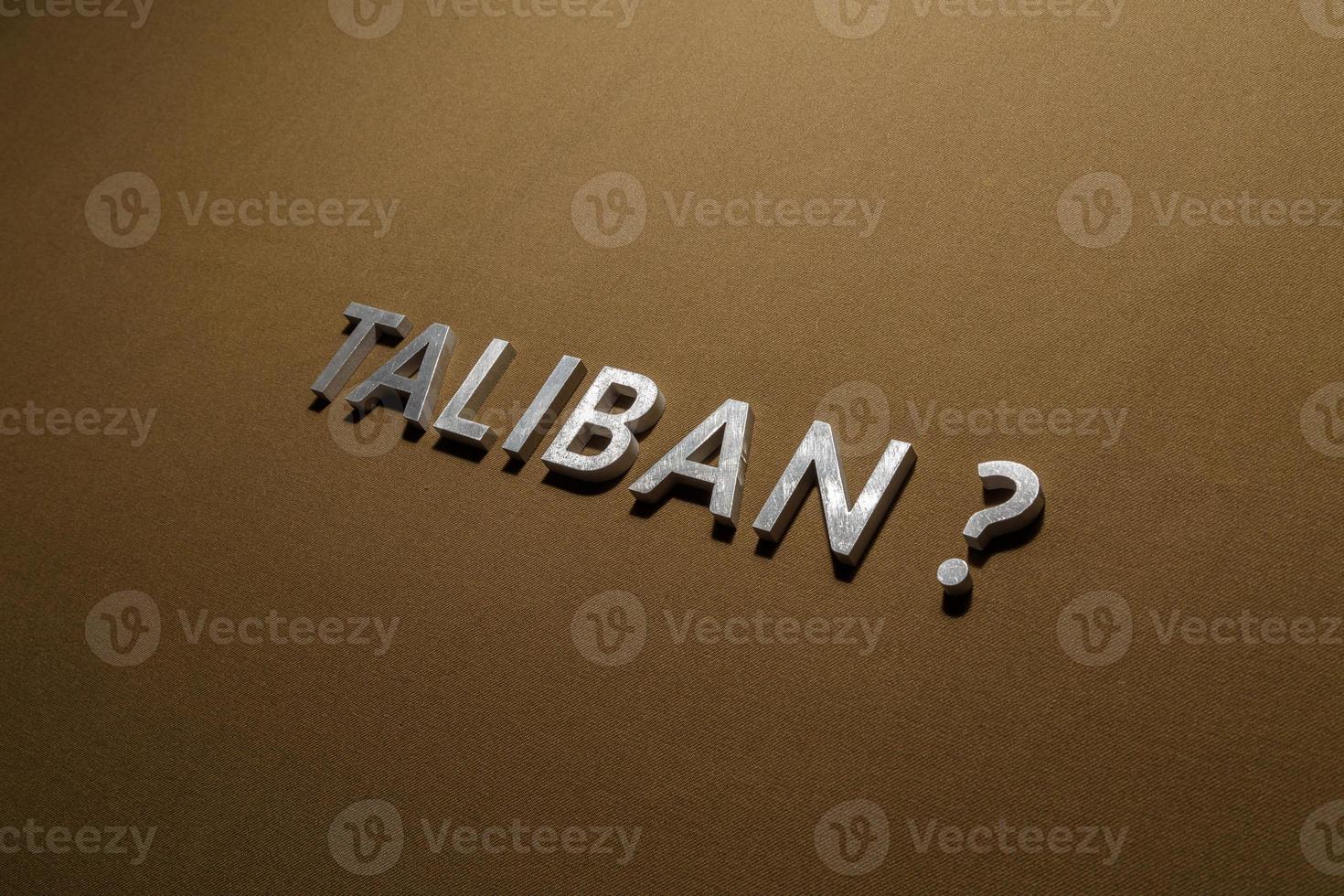 the question taliban laid with silver metal letters on rough tan khaki canvas fabric photo