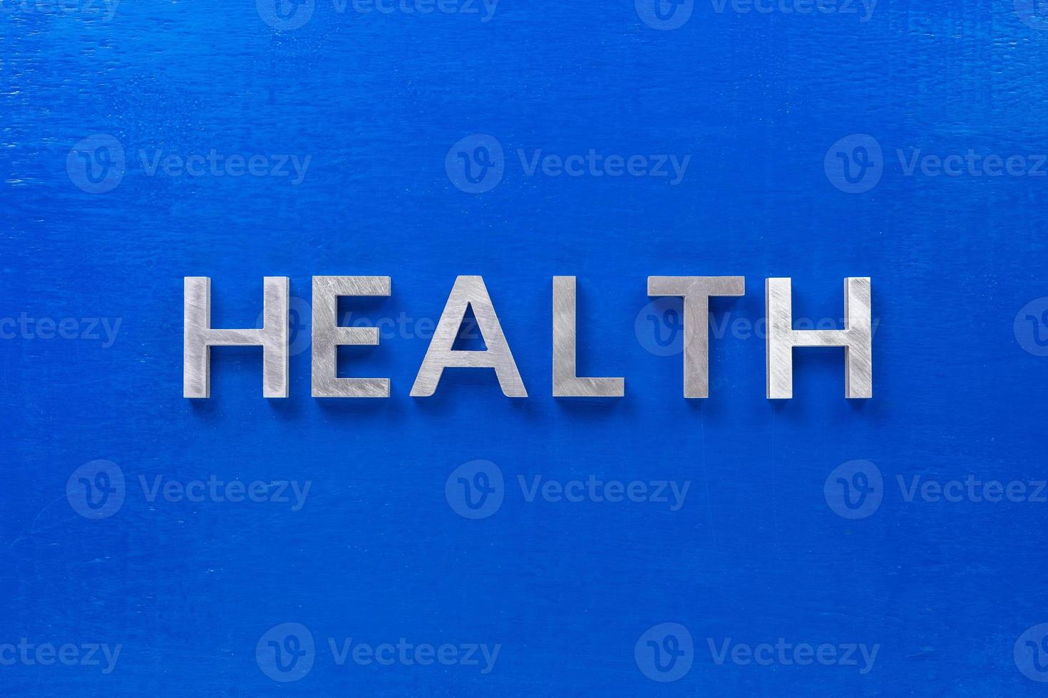 the word health laid with silver metal characters on blue painted wooden board in central flat lay composition photo