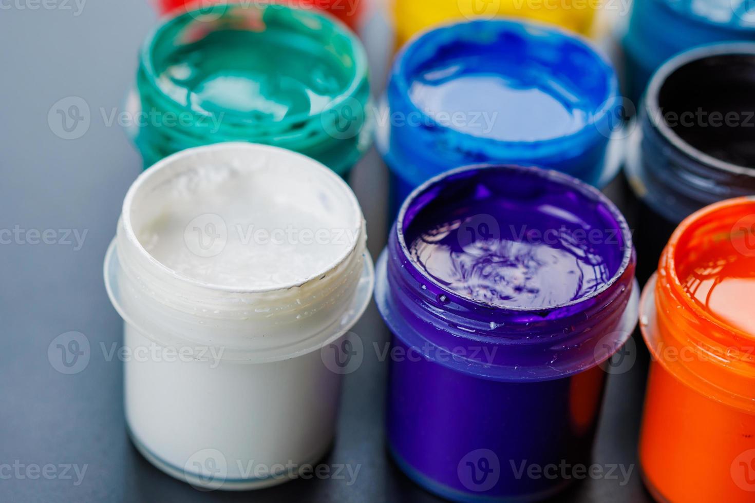 full-frame close-up background of opened small gouache paint jars photo