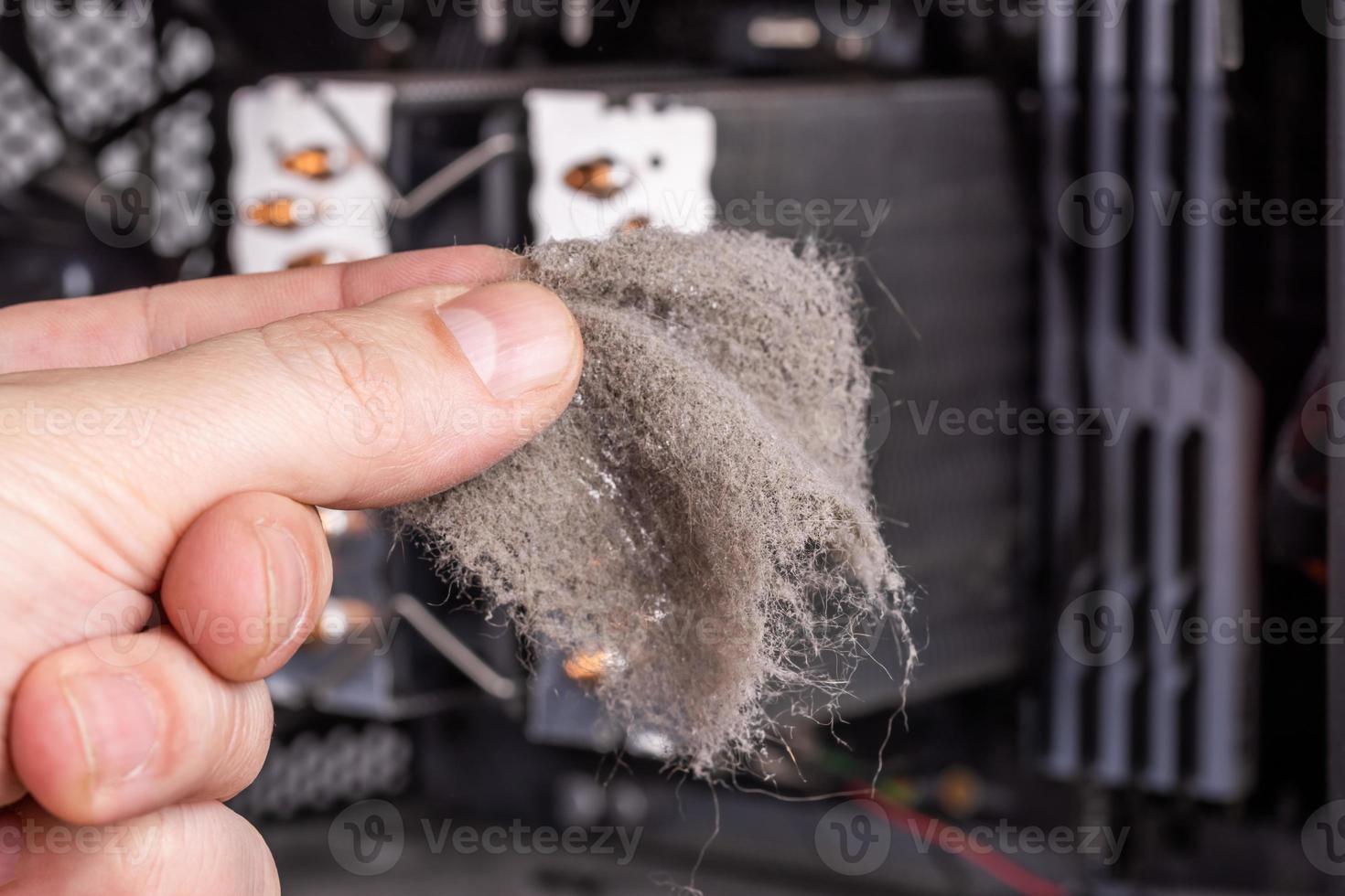 bare caucasian hand removing dust clog fromf opened pc case during maintenance photo