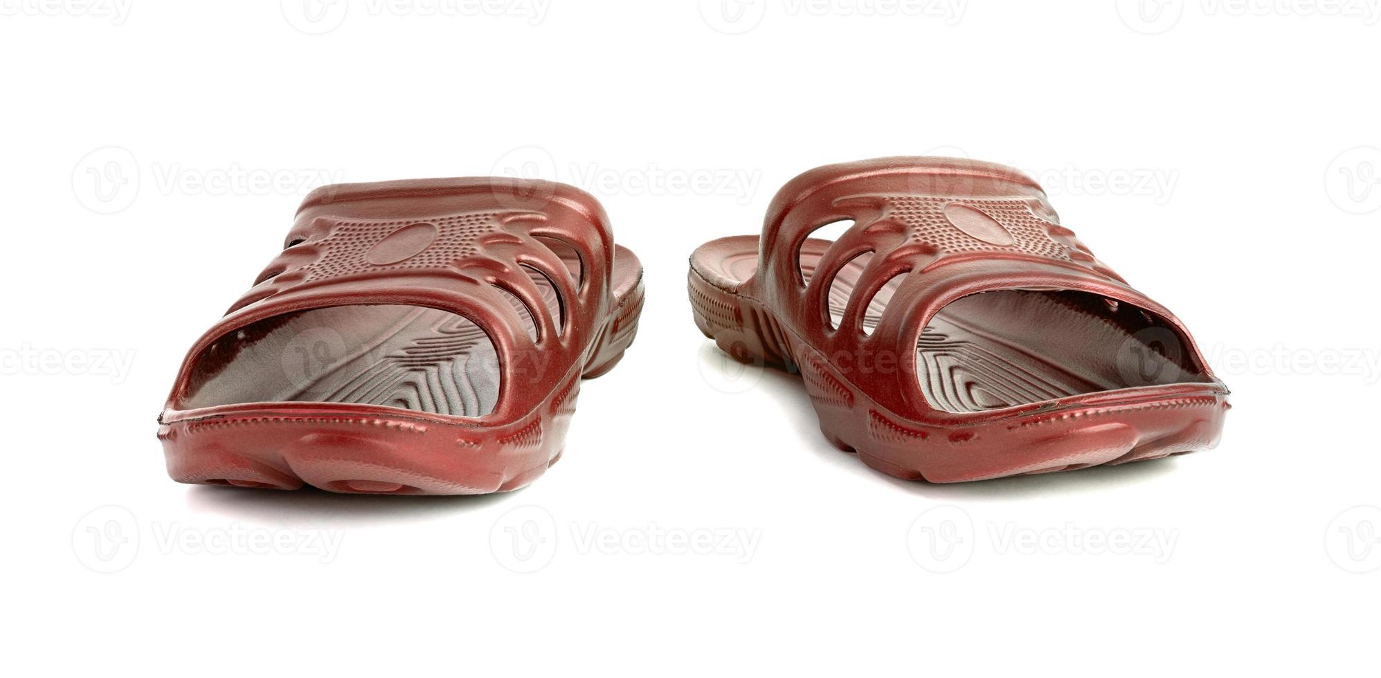 pair of cheap durable orange rubber slippers isolated on white background. photo