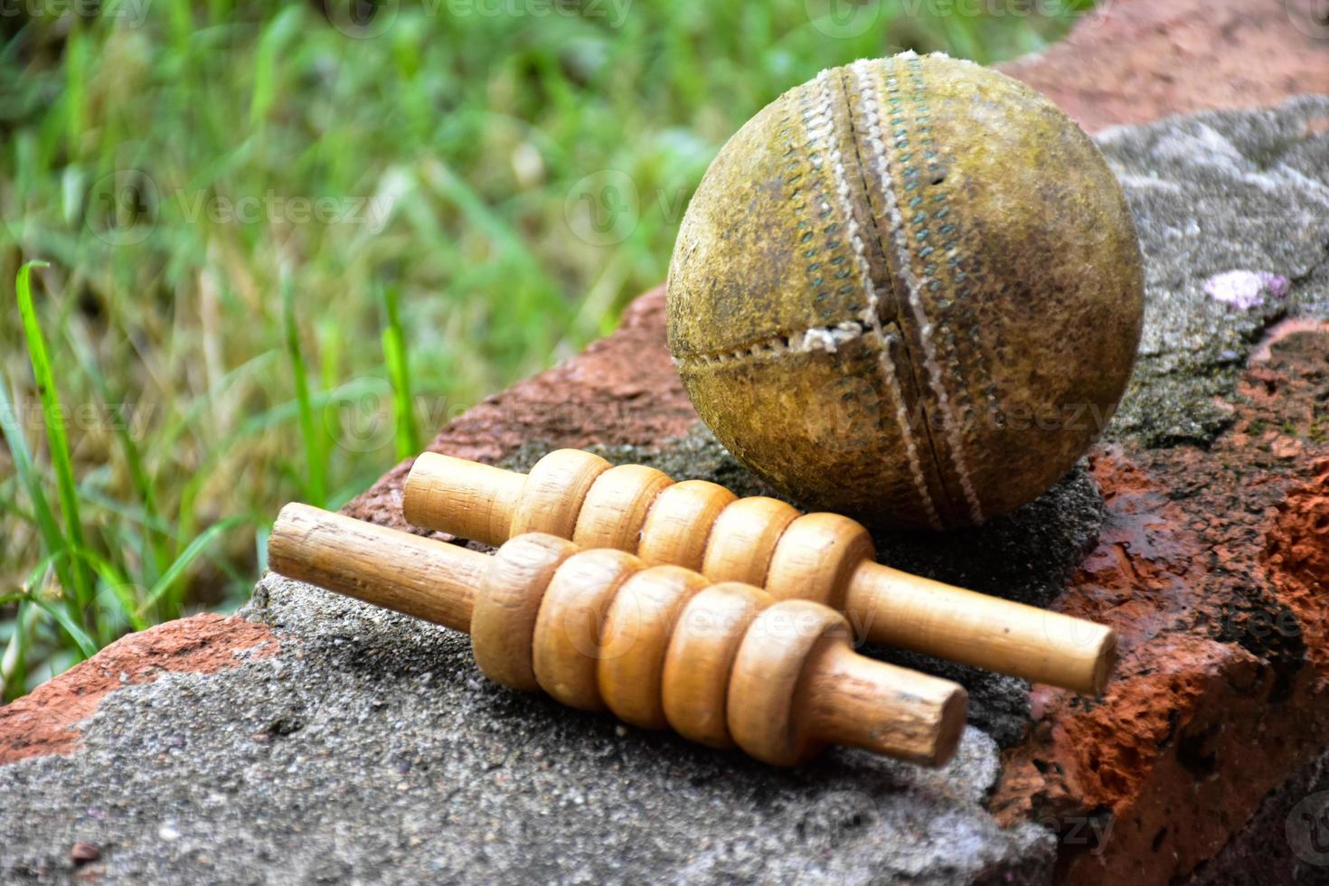 equipos deportivos de cricket en ladrillo, bate, wicket, pelota de cuero vieja, enfoque suave y selectivo. foto