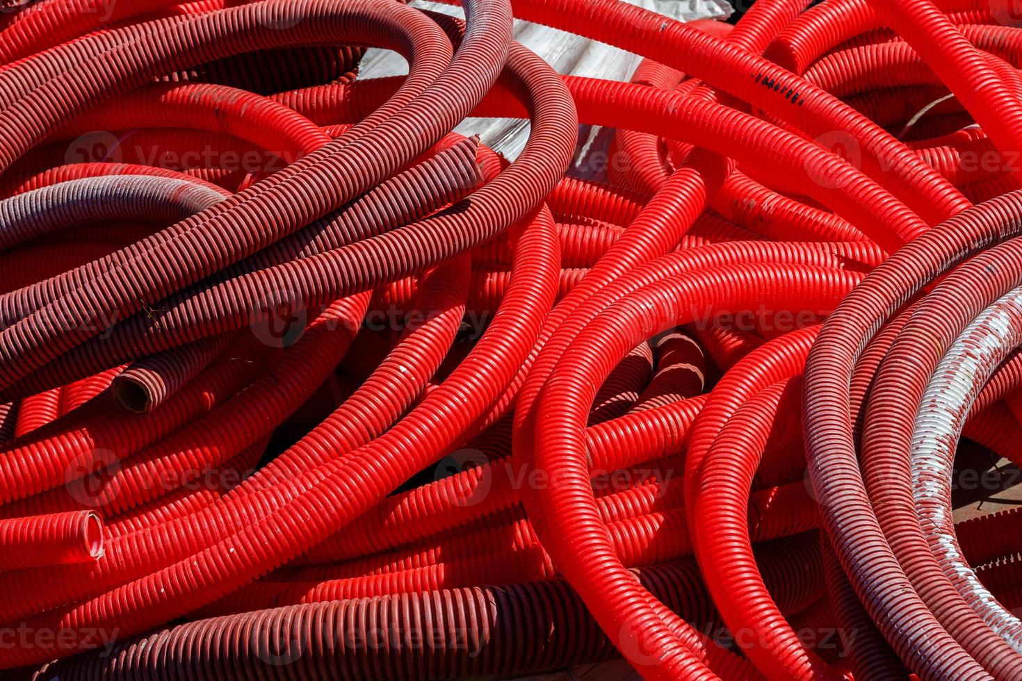 red corrugated PVC pipes for cable lay on the construction site photo