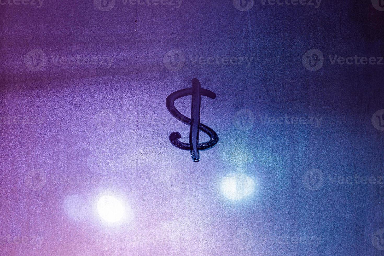 Dollar currency sign handwritten on fogged window. Dollar symbol on wet night window surface. photo