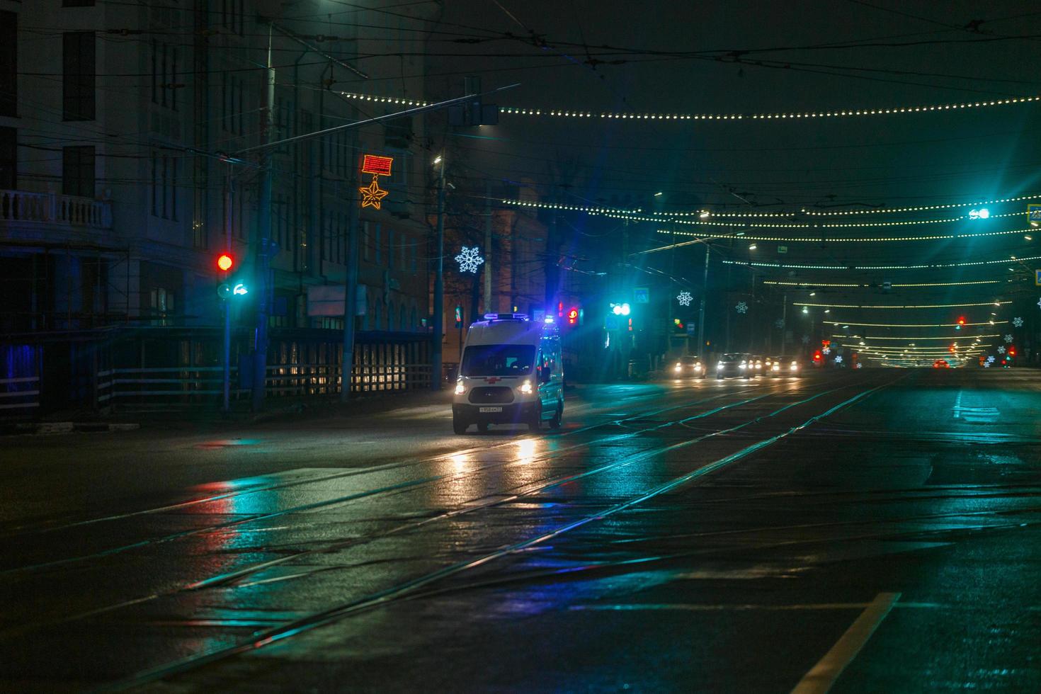 tula, rusia 31 de diciembre de 2020 ambulancia moviéndose hacia la cámara en una calle nocturna vacía en la ciudad foto