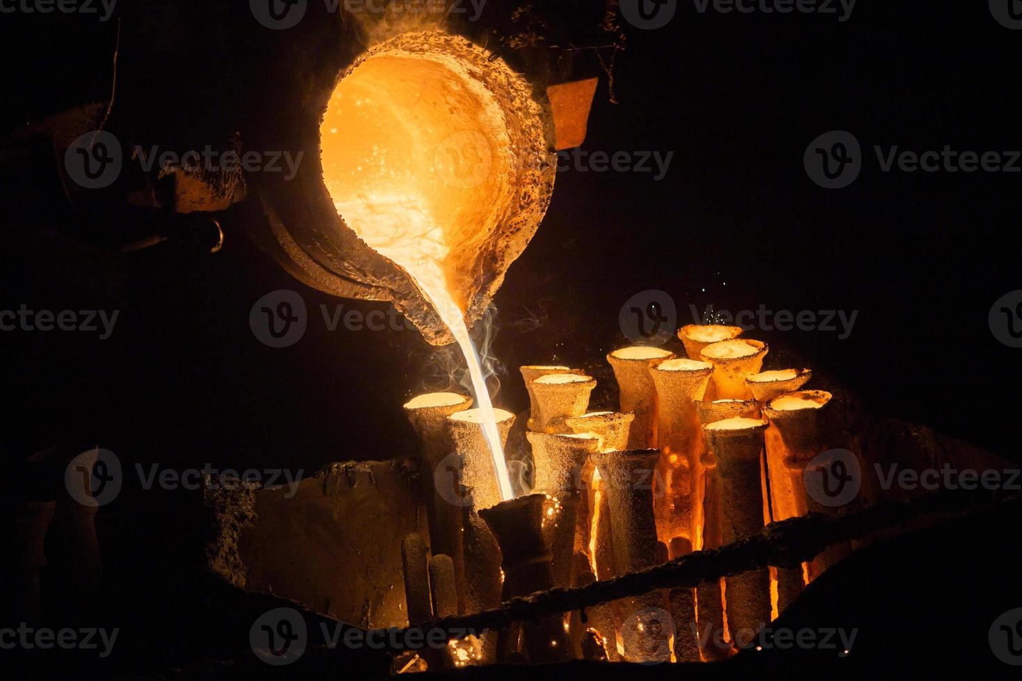 Industrial lost wax casting. The process of pouring for filling out ceramic shells with molten steel. photo