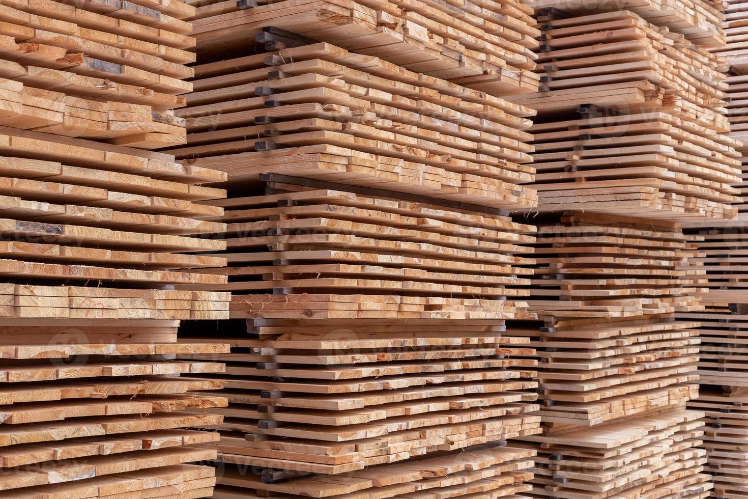 large stacks of wooden planks full frame background with selective focus and linear perspective photo
