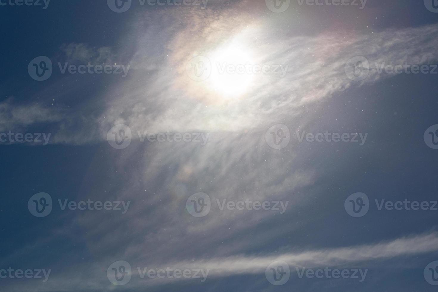 partículas de polvo en el cielo azul con nubes de sol y plumas en el día de primavera foto