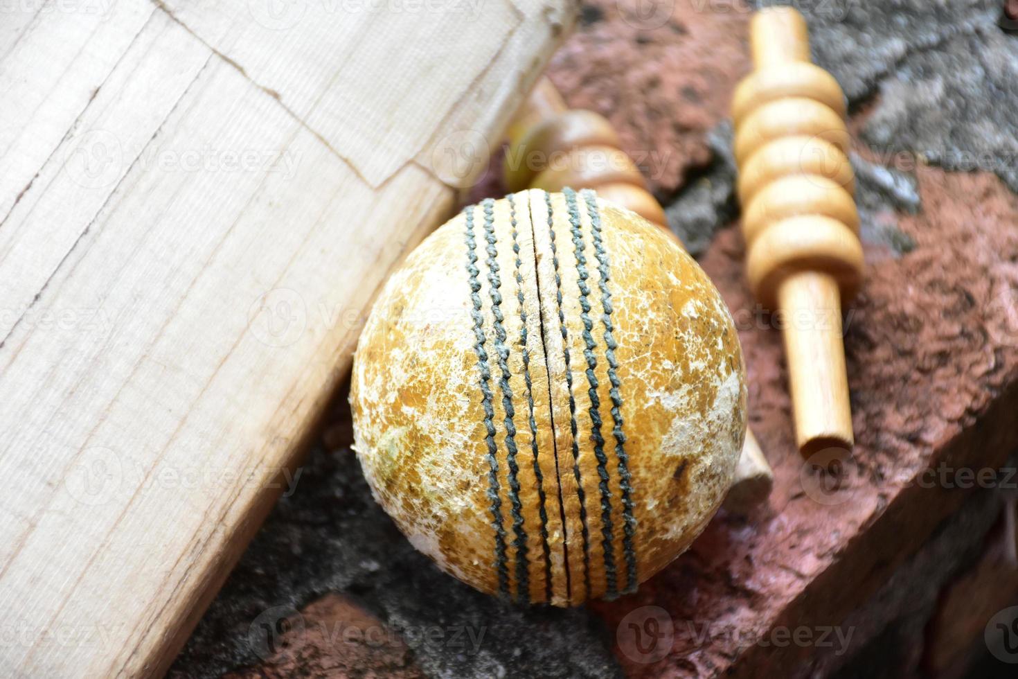 Cricket sport equipments on brick, bat, wicket, old leather ball, soft and selective focus. photo