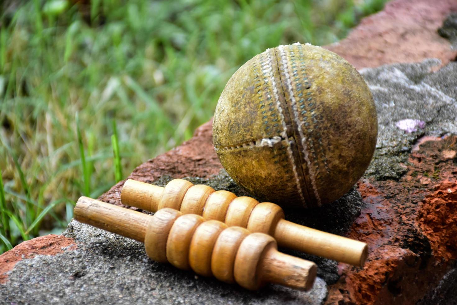 equipos deportivos de cricket en ladrillo, bate, wicket, pelota de cuero vieja, enfoque suave y selectivo. foto