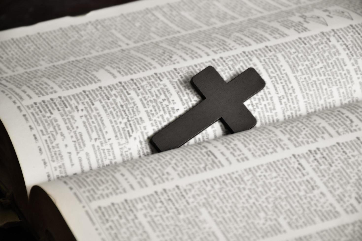 Brown wooden cross in the center of the page of the english grammar book, soft and selective focus. photo