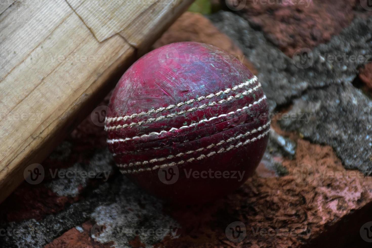 Cricket sport equipments on brick, bat, wicket, old leather ball, soft and selective focus. photo