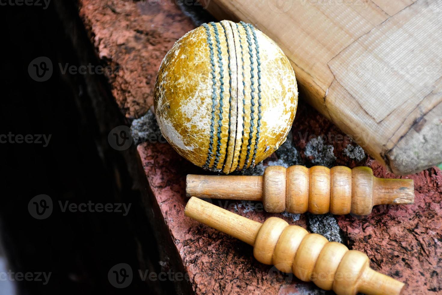 Cricket sport equipments on brick, bat, wicket, old leather ball, soft and selective focus. photo