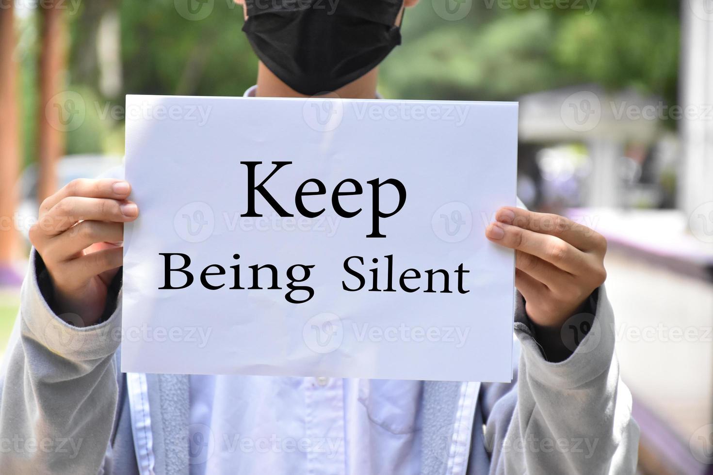 un estudiante asiático sostiene un libro blanco que tiene textos que siguen en silencio por dentro, concepto para protestar o llamar a todas las personas del mundo para que sigan en silencio o en silencio. foto