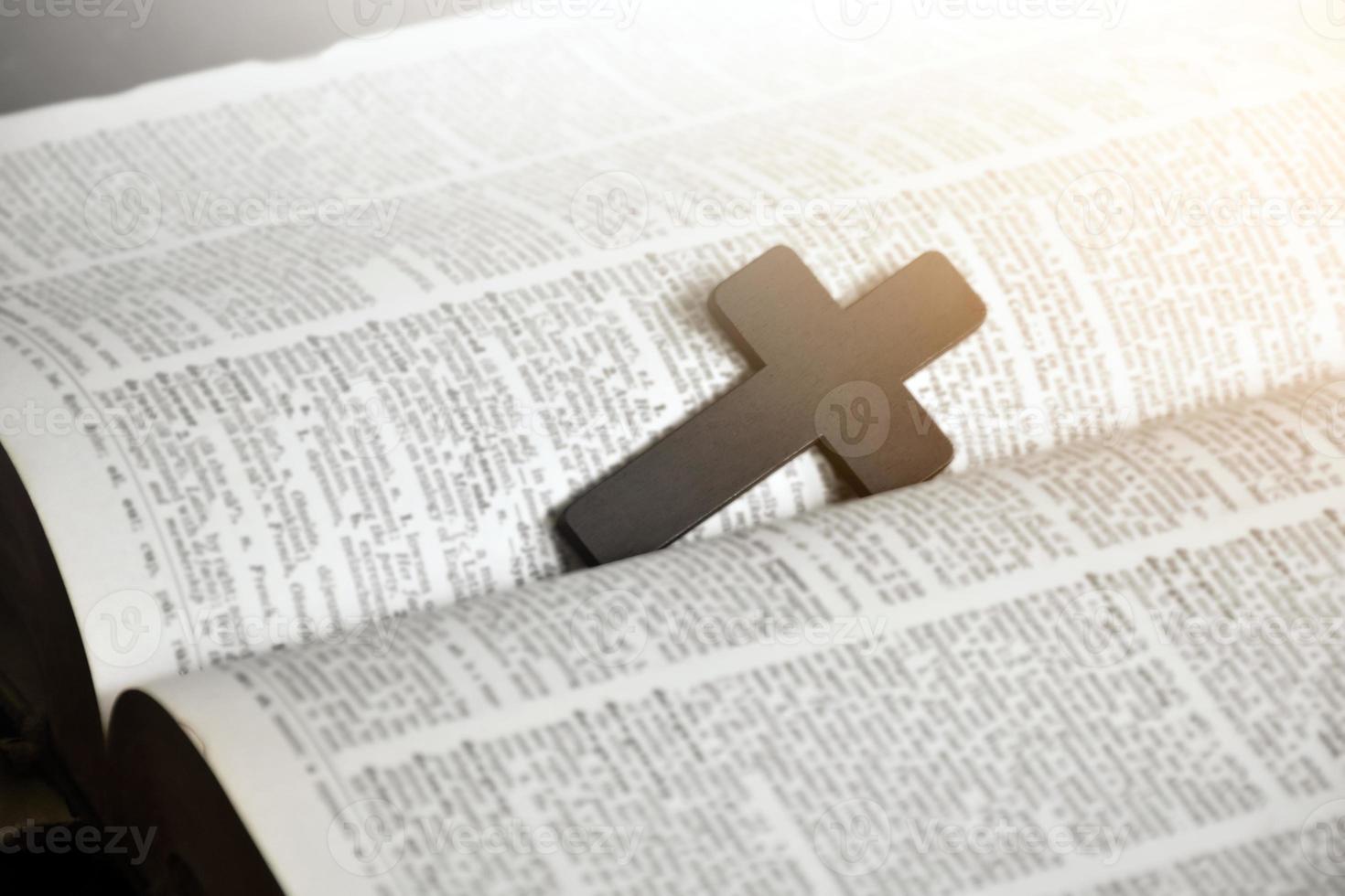 Brown wooden cross in the center of the page of the english grammar book, soft and selective focus. photo