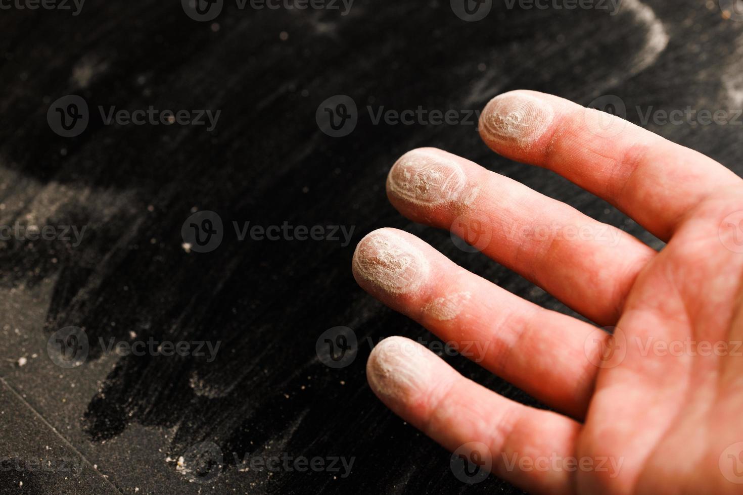 caucasian hand with dust on finger tips after touching black dusty surface photo