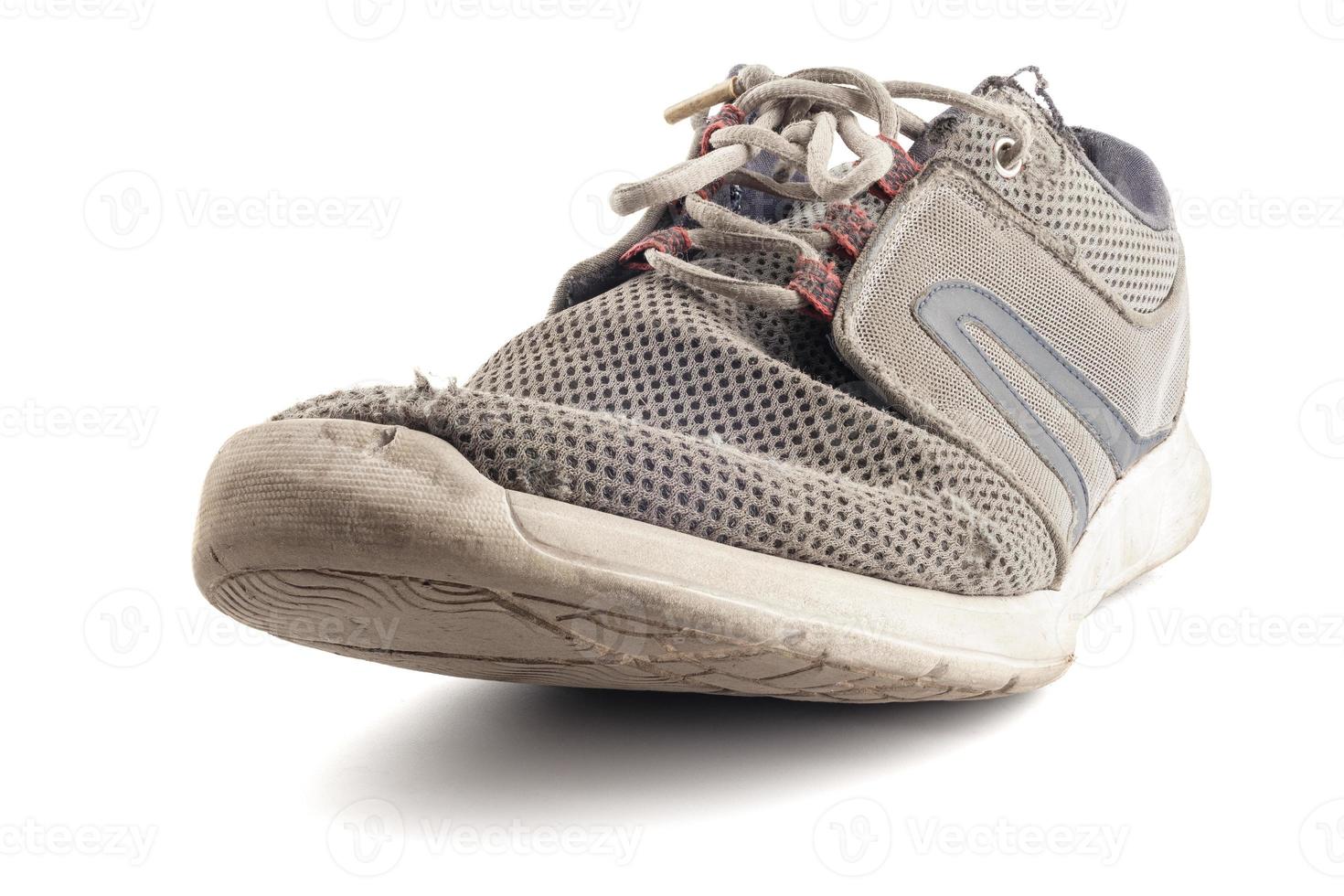 one worn out sneaker isolated on white background photo