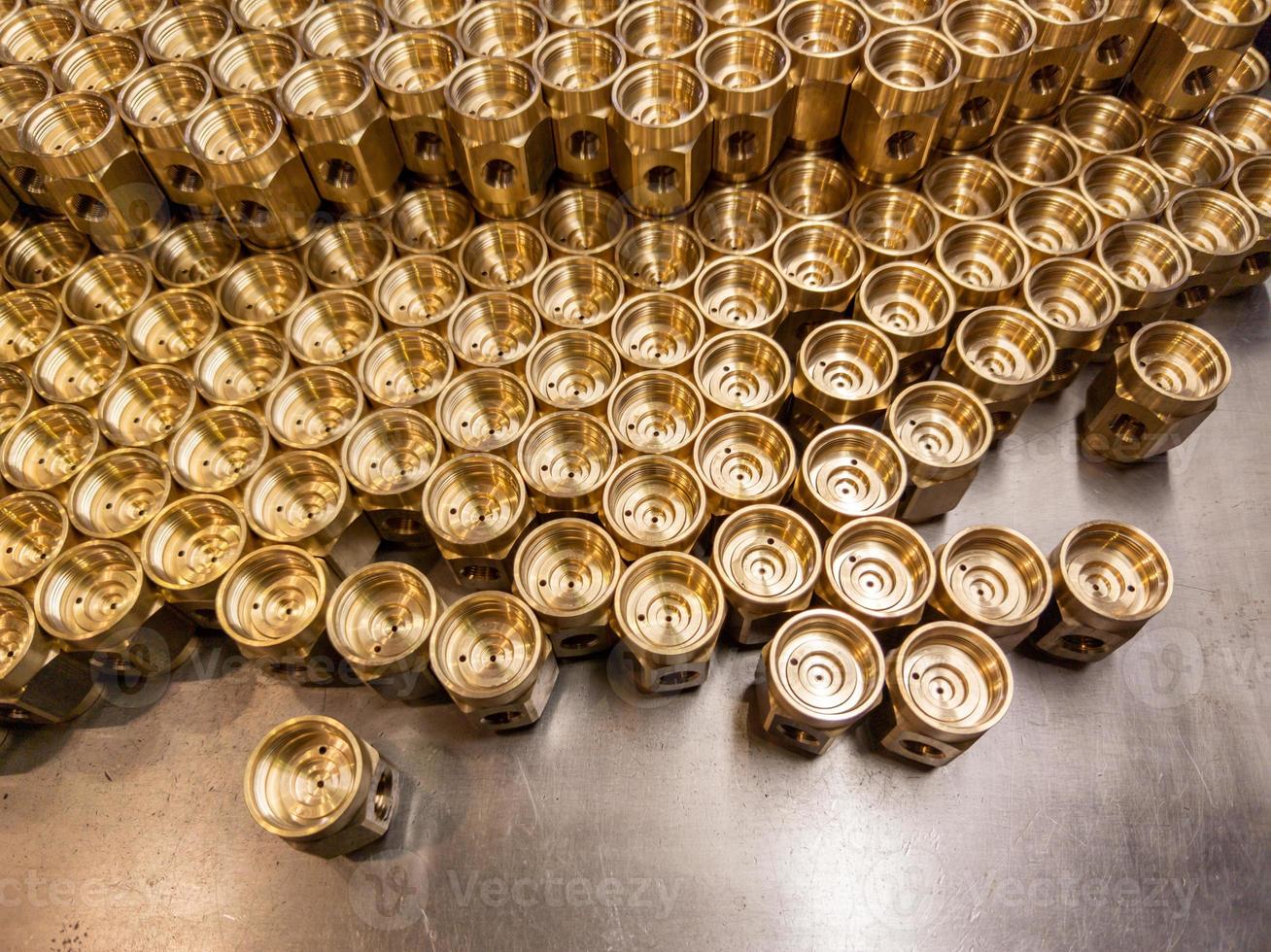Shiny yellow metal parts background. Shiny brass metal threaded hexagonal parts after turning and machining. photo