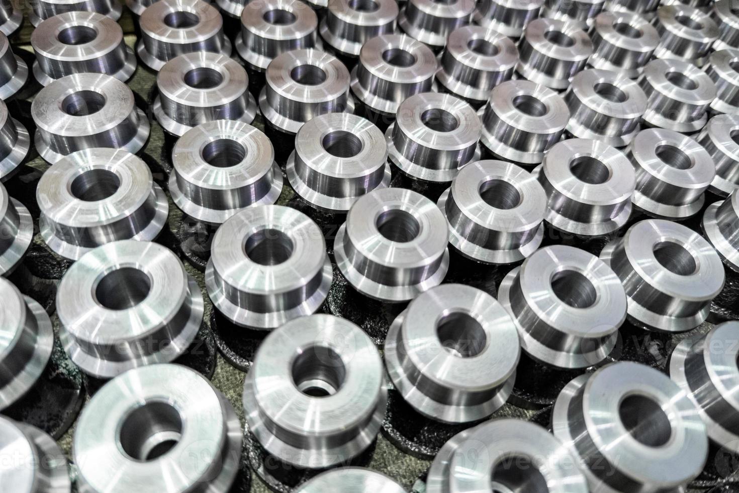 batch of shiny round steel parts background, close-up with selective focus and blur photo