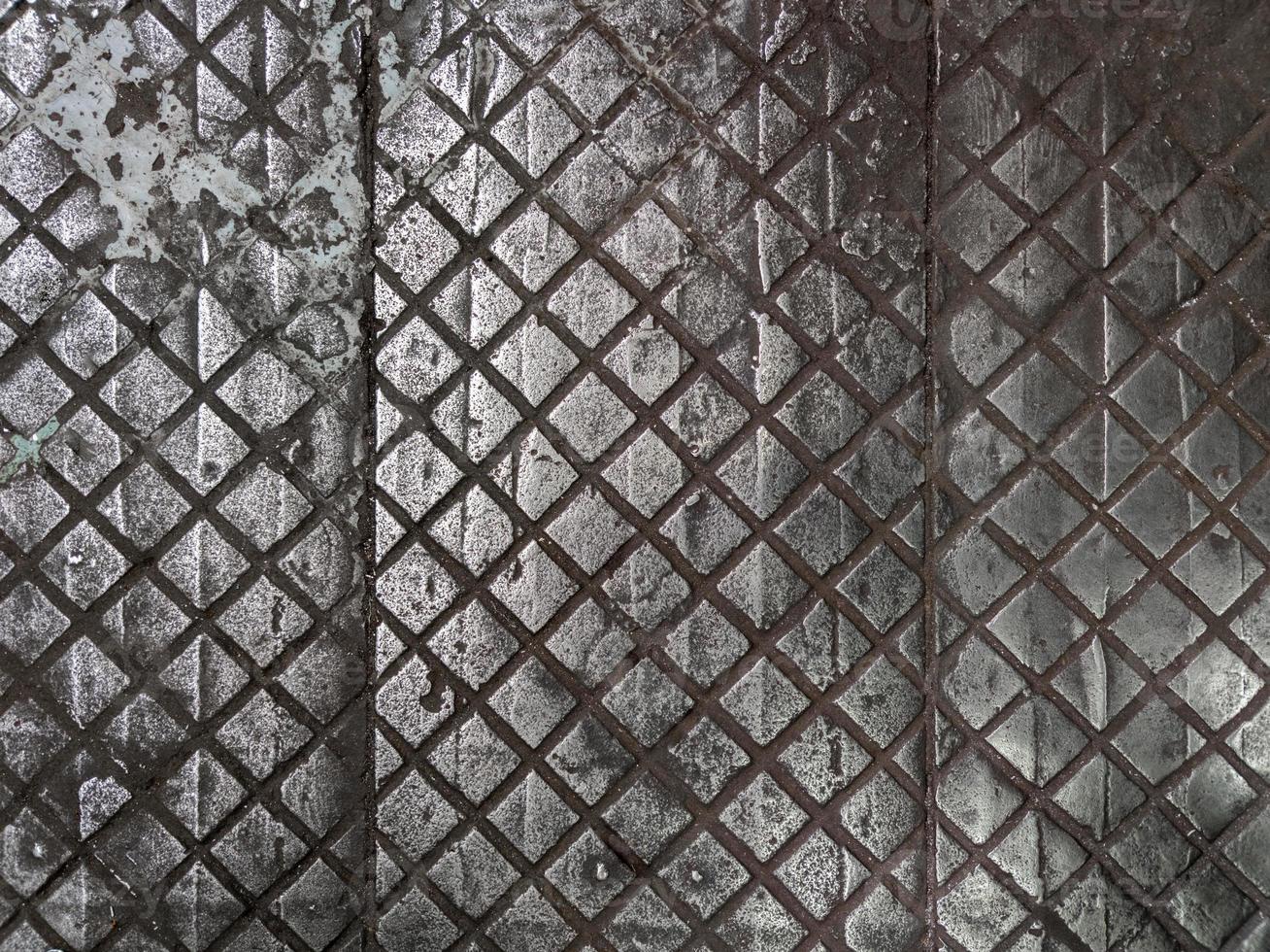 old cast iron factory floor tiles with checkered skid-proof pattern photo