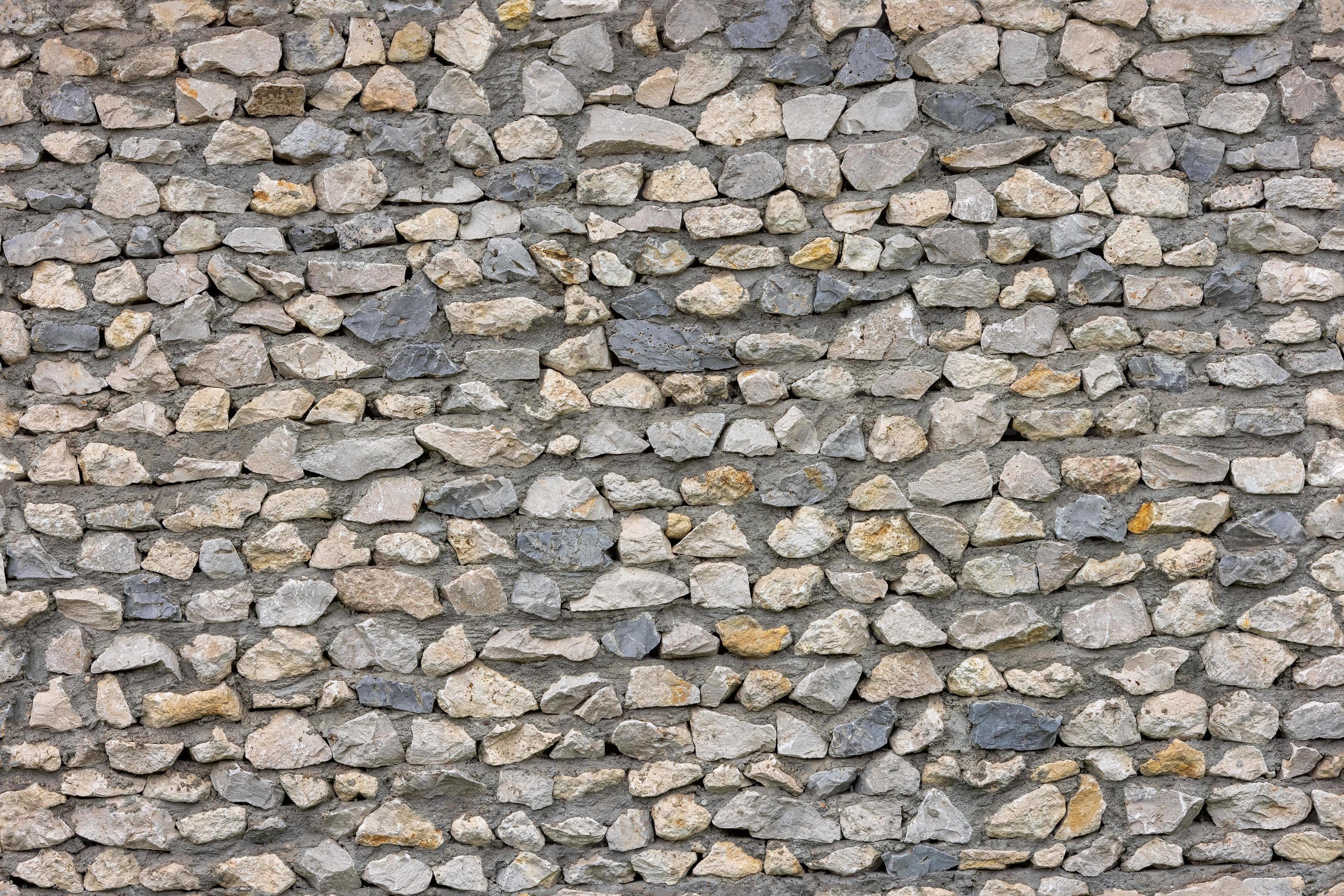 seamless texture of ugly sharp stone wall with concrete between rocks