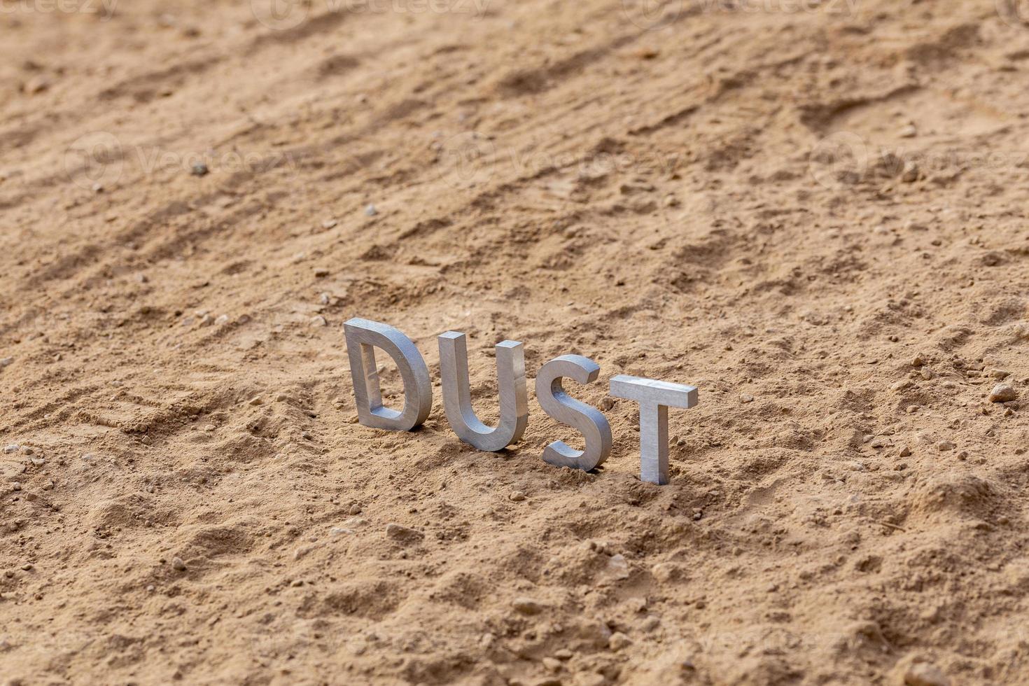the word dust standing on dusty road surface in linear perspective photo