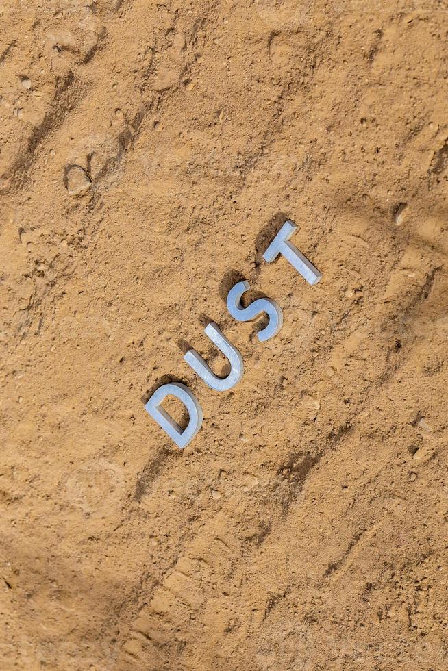 the word dust on dusty road surface in flat lay perspective photo