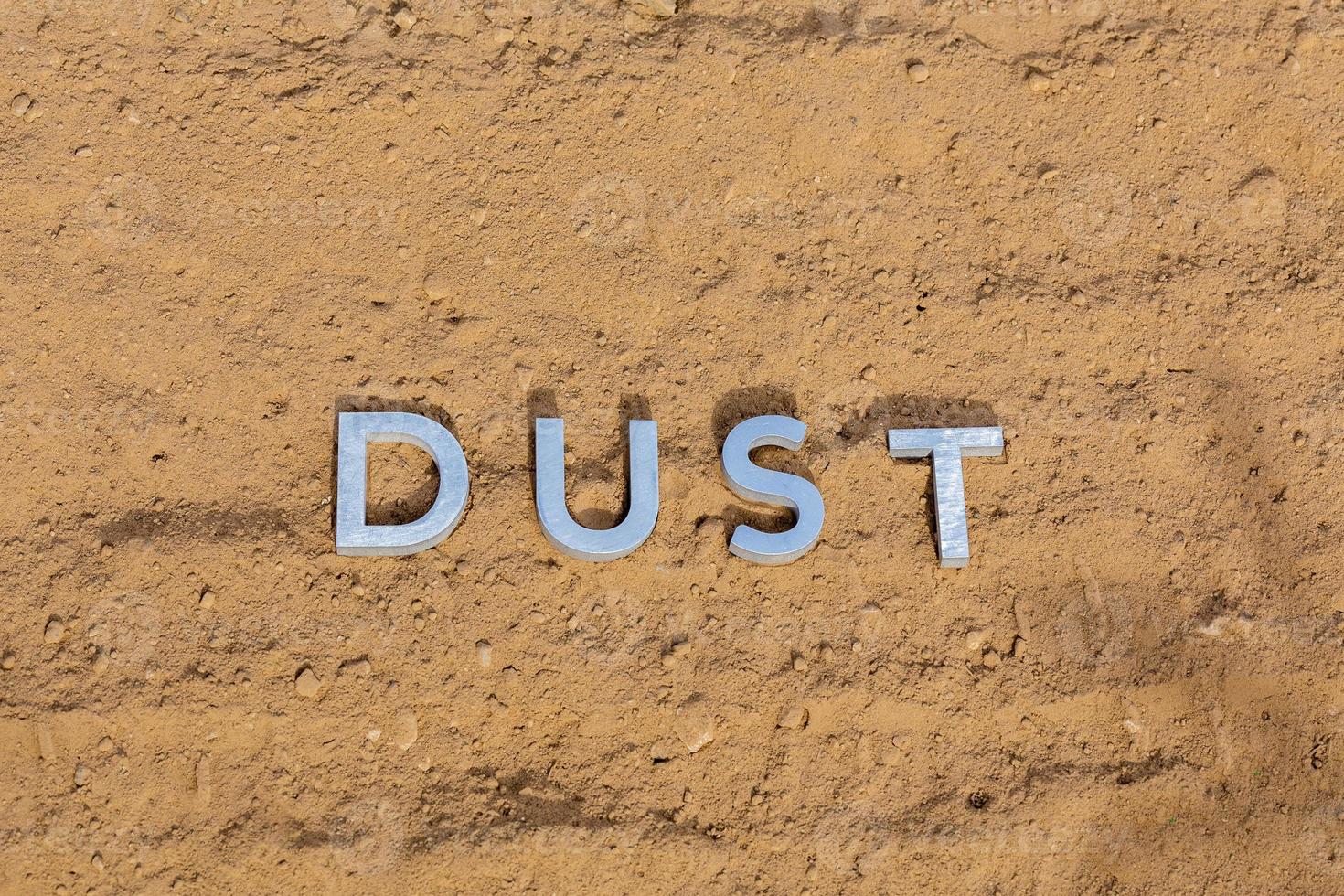 the word dust on dusty road surface in flat lay perspective photo