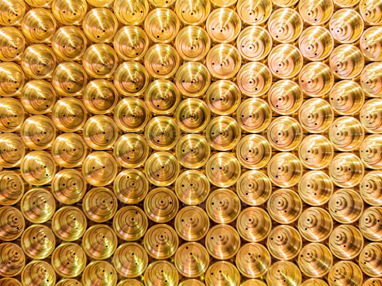 abstract industrial background of shiny brass metal threaded hexagonal parts photo