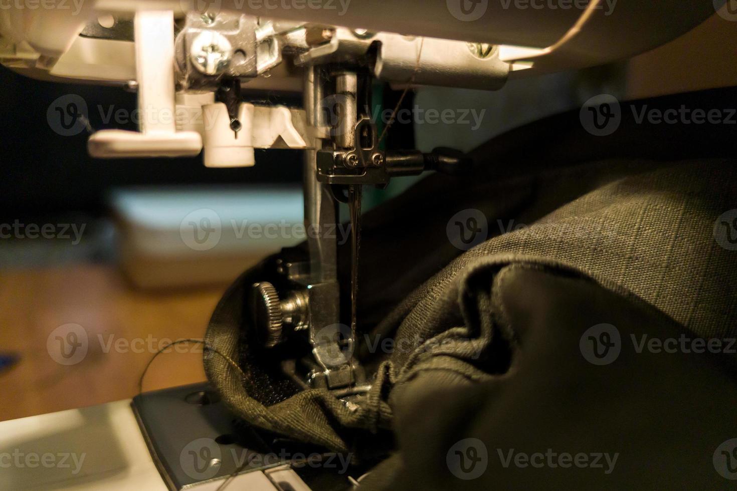 a dark gomestic sewing with machine and green military cloth photo