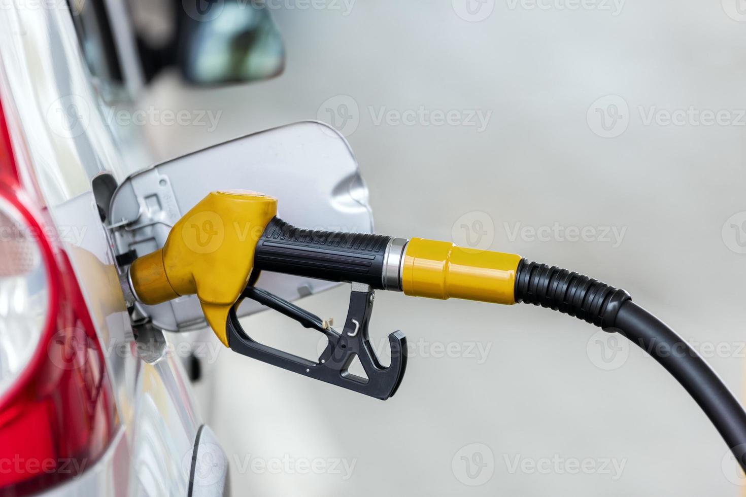 Silver car refuelling at the gas station, the concept of fuel energy photo