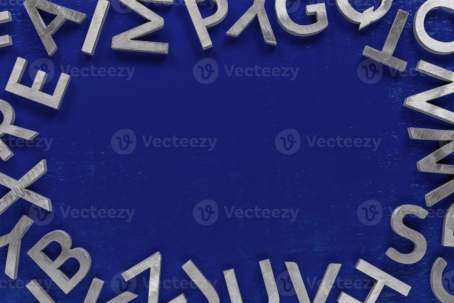 Frame mockup made of of silver metal english alphabet characters on blue background. photo