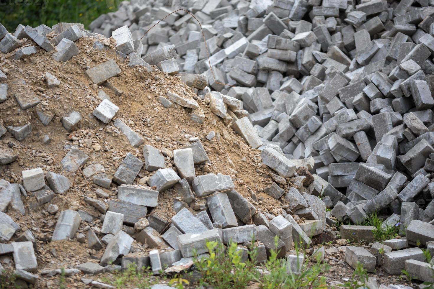 Pile of disassembled gray pavement bricks with selective focus photo